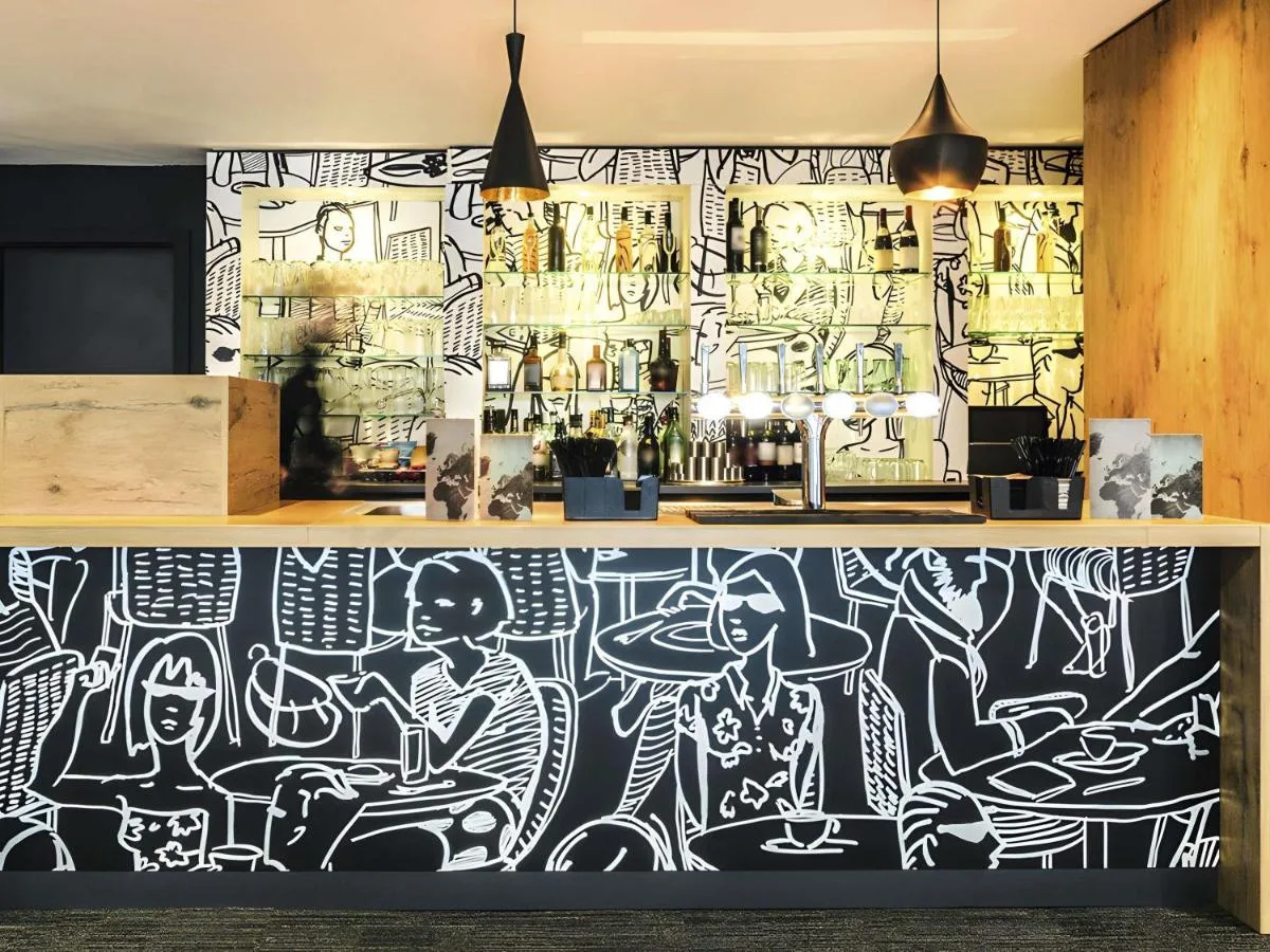 A mural of people sitting at tables in the restaurant at ibis Liverpool Centre Albert Dock – Liverpool One