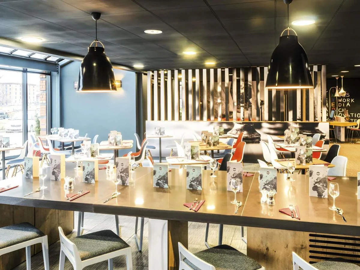 A restaurant with a large table and chairs at ibis Liverpool Centre Albert Dock – Liverpool One